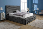 Gray tufted bed in a bedroom with blue walls and decorative elements.