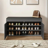 Black shoe storage bench with shoes on shelves in a room setting.