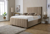 Beige upholstered bed in a modern bedroom setting with decor elements.