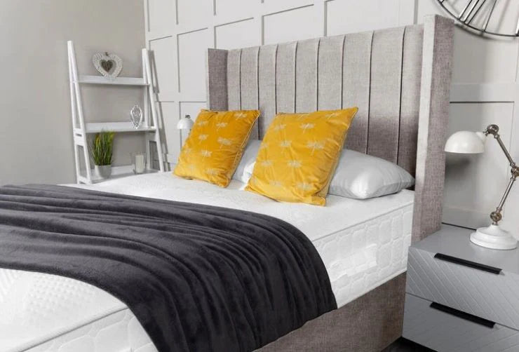 Bedroom with a bed featuring gray headboard, white bedding, and yellow pillows.