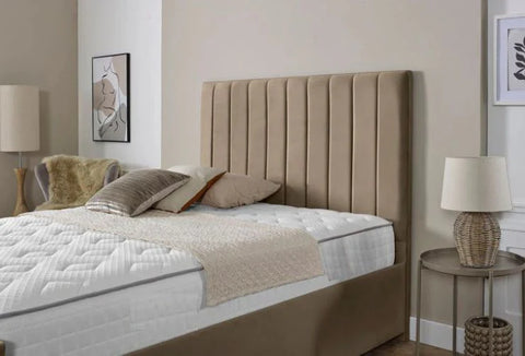 Beige upholstered bed with white bedding in a bedroom setting.