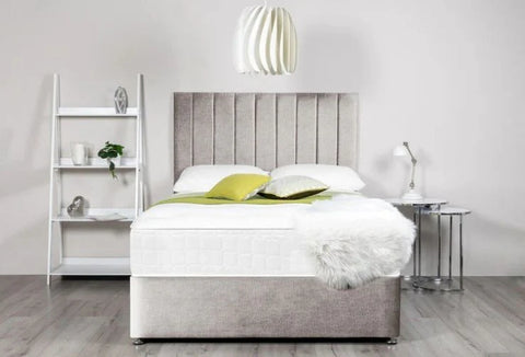 Bedroom with a bed featuring a gray headboard and white bedding, next to a white shelf and nightstand.