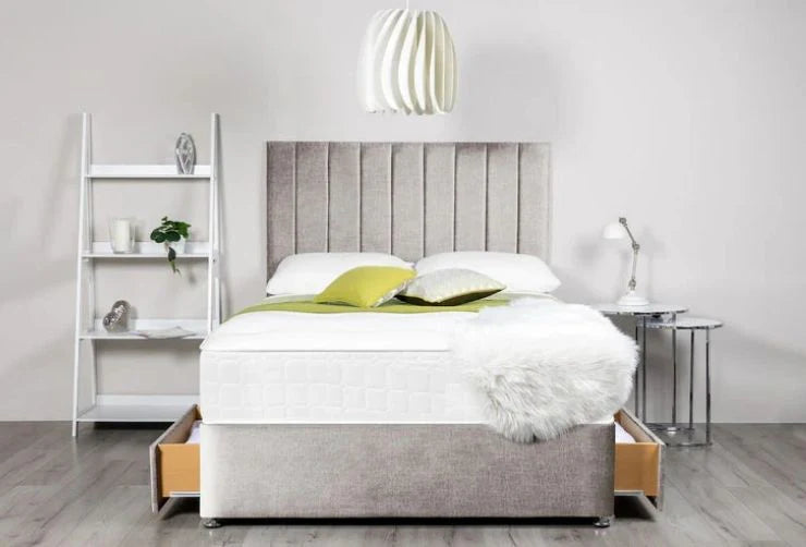 Gray upholstered bed with white bedding in a modern bedroom setting.