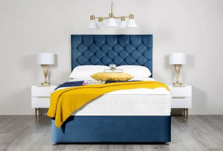 Blue upholstered bed with white mattress and yellow blanket in a bedroom setting.